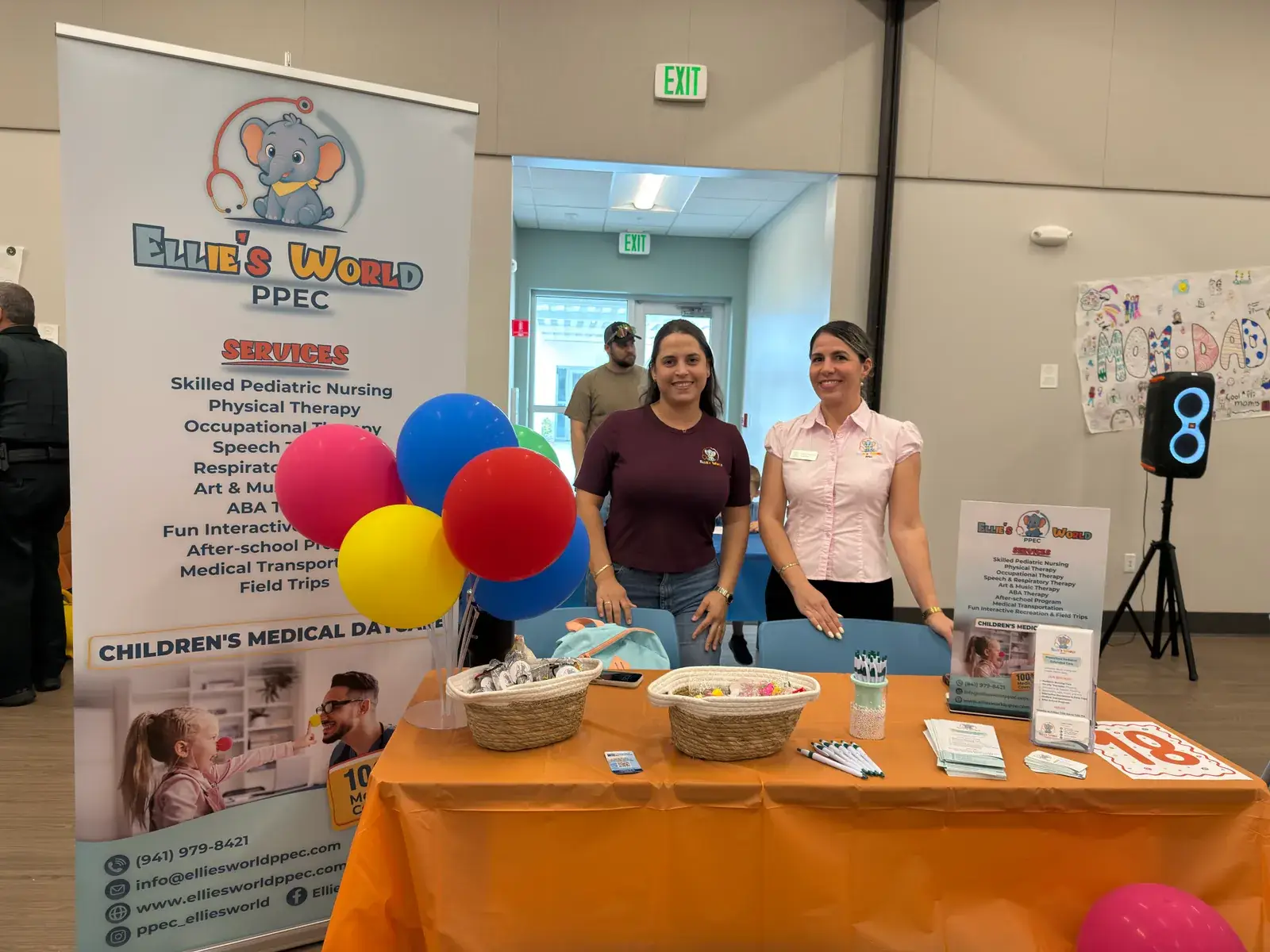 Two staff members at the Ellie's World PPEC information table during a community health fair in Port Charlotte, Florida