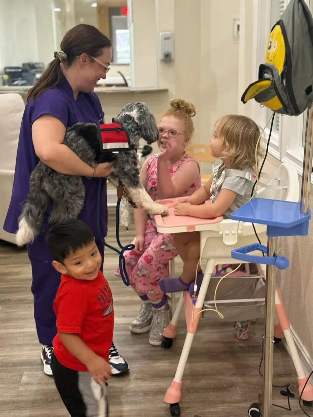 Children meeting a visiting therapy dog at Ellie's World PPEC in Port Charlotte, Florida