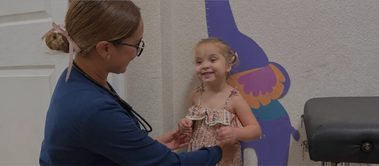 A licensed nurse checking a smiling young girl during her daily assessment at Ellie's World PPEC in Port Charlotte, Florida
